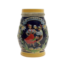 Decorative beer stein with a Bierfest theme, featuring embossed artwork of two individuals in traditional German attire, toasting with beer mugs. The central motif is framed by edelweiss flowers and greenery on a navy blue background, capped with a cream-colored rim with the word 'BIERFEST' prominently displayed.